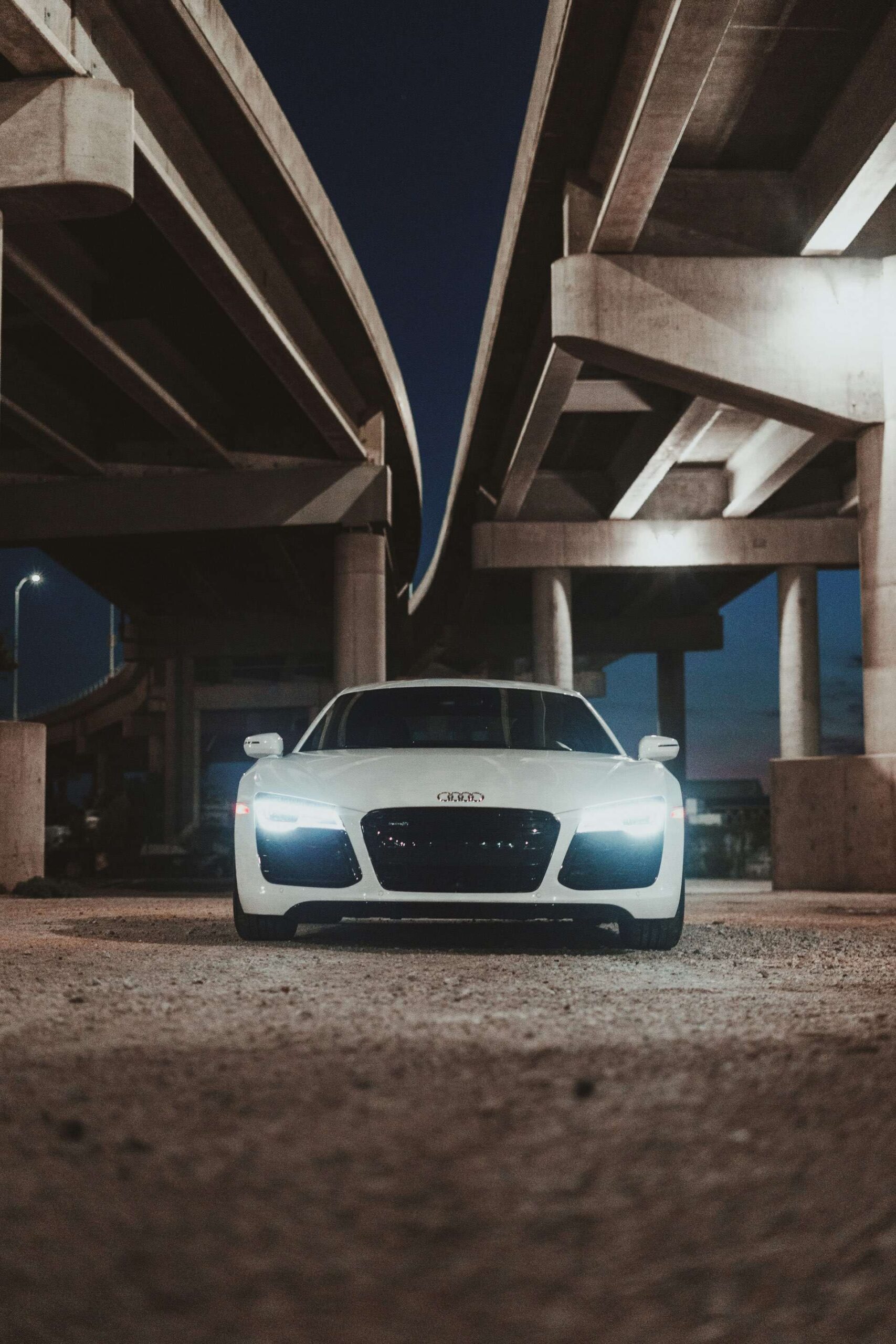 Front, low angle shot of an Audi R8 under a bridge.