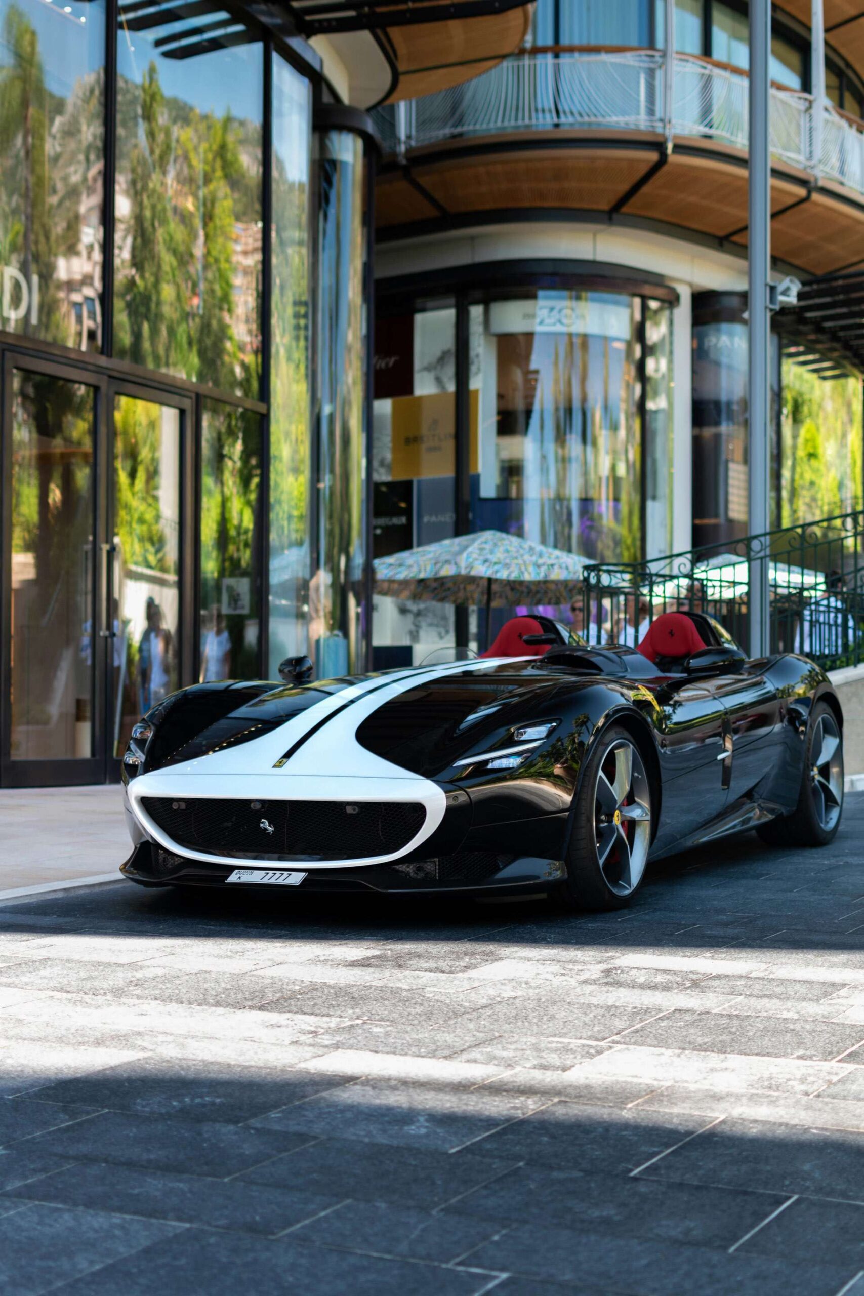 Ferrari classic super car parked outside the front of a hotel.