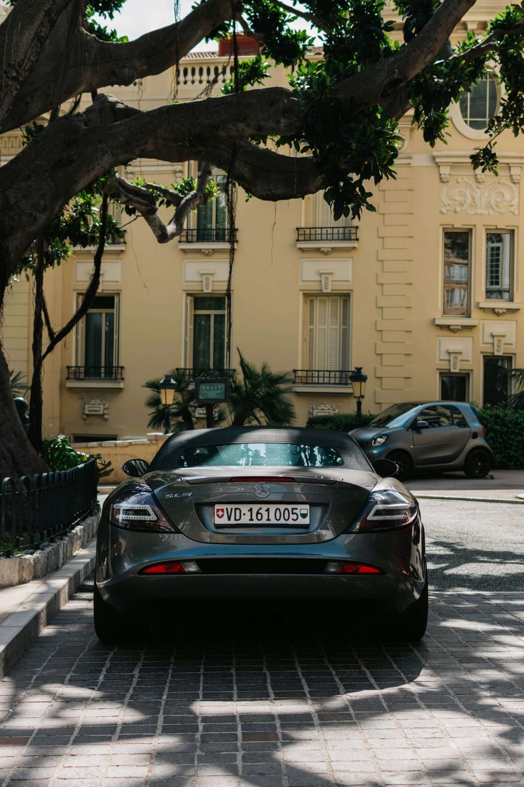 Rear view of a mercedes super car parked on the side of a road in a sunny country.