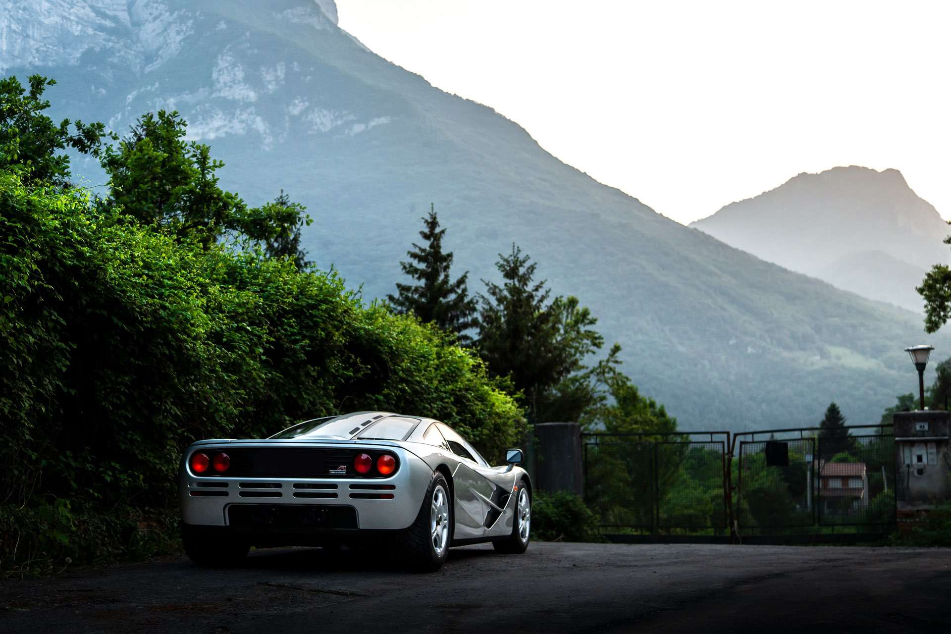 View of a high performance super car from the rear, in front of a stunning range of mountains.