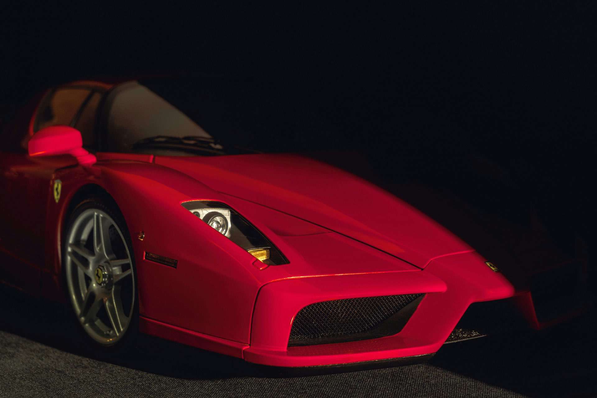 Front end of a Ferrari Enzo sneaking out from the dark.