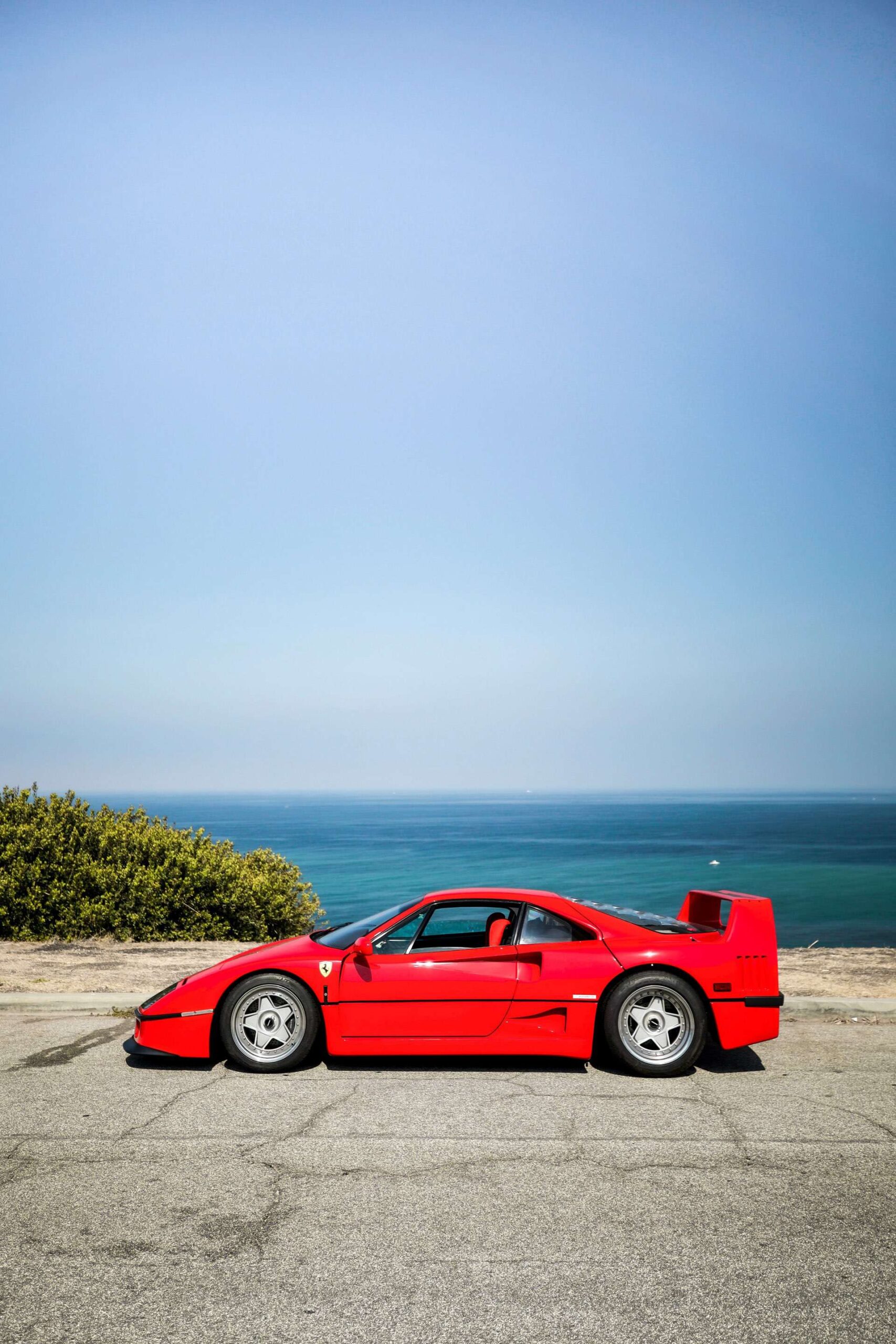 Side view of a Ferrari F40 in front of an ocean view.