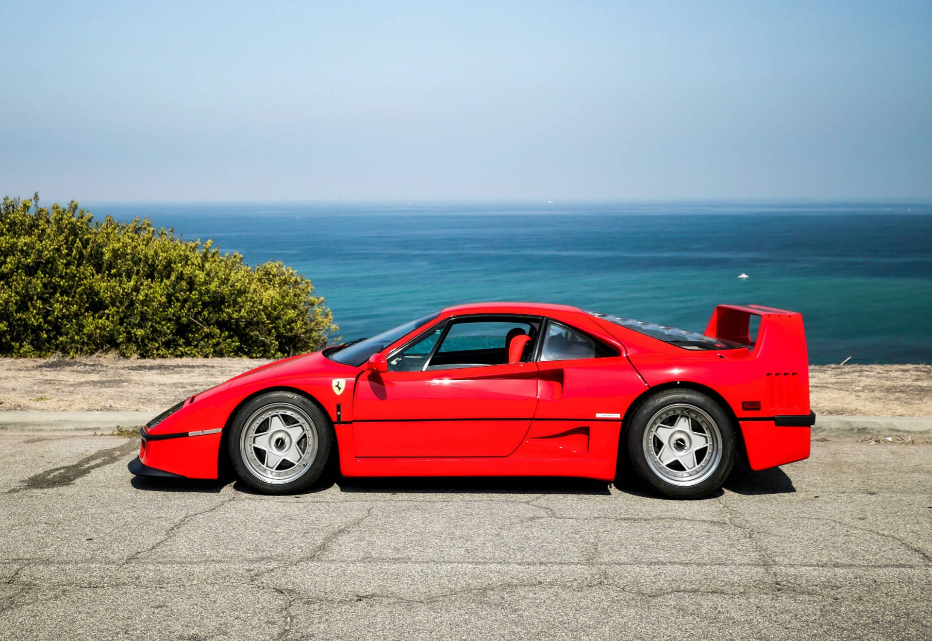 Side view of a Ferrari F40 in front of an ocean view.